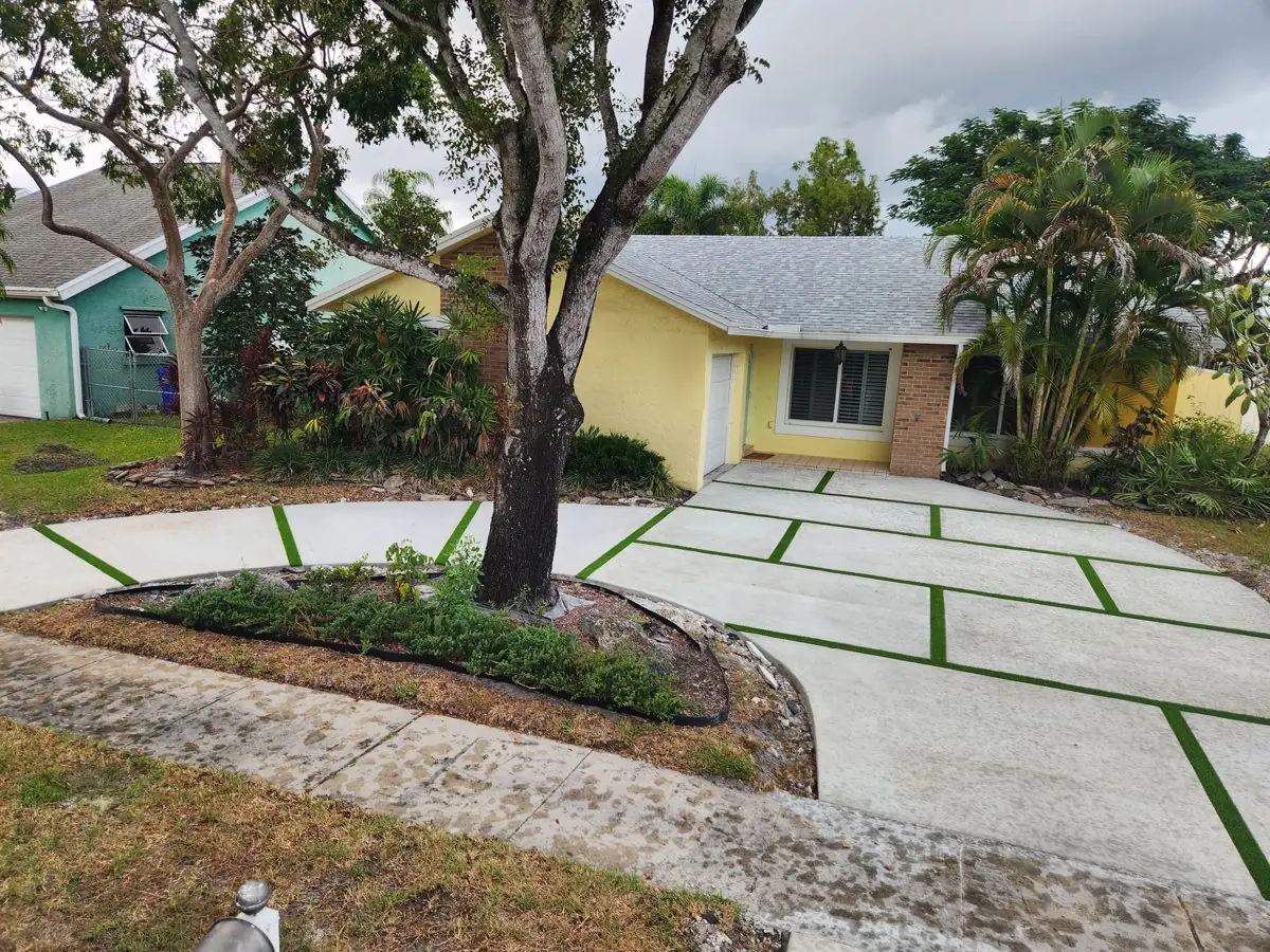 Same home after: concrete pads with artificial-turf joints around the tree