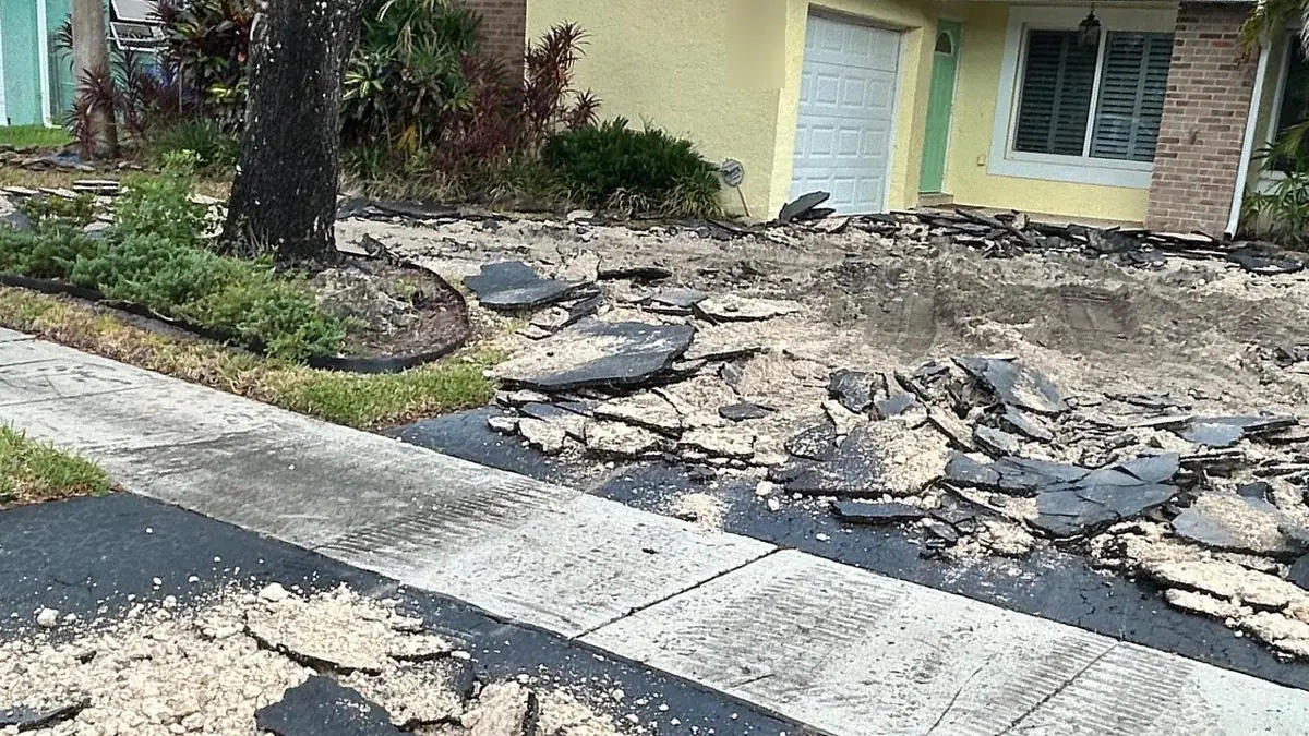 Old asphalt driveway broken up during demolition