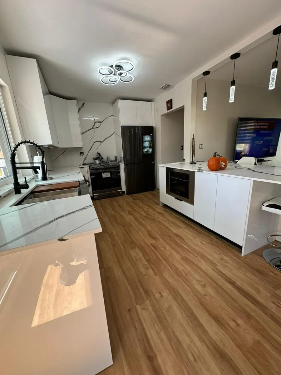 Open kitchen with quartz island — Kitchen remodel by Proper Roofing